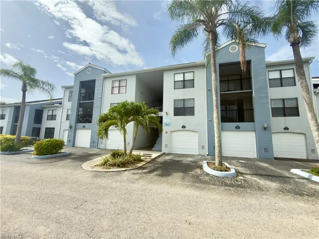 Multi-story residential building featuring a light gray and blue exterior facade