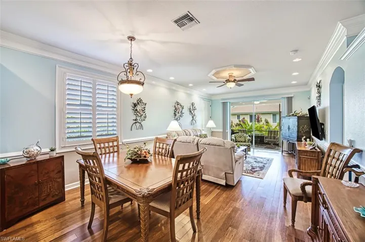 Dining space with ornamental molding, ceiling fan, and dark hardwood / wood-style floors