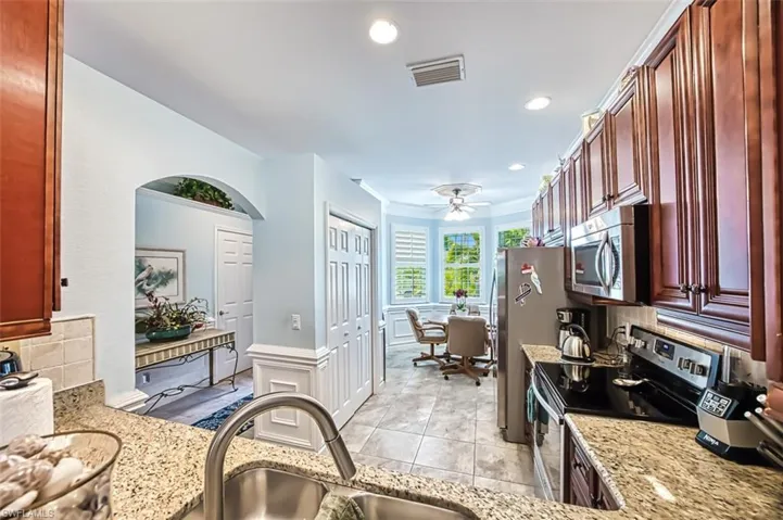 Kitchen with ceiling fan, tasteful backsplash, sink, and appliances with stainless steel finishes