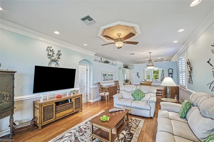 Living room with crown molding, ceiling fan, and hardwood / wood-style floors