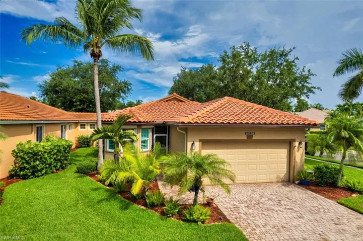 Mediterranean / spanish-style home with a garage and a front yard