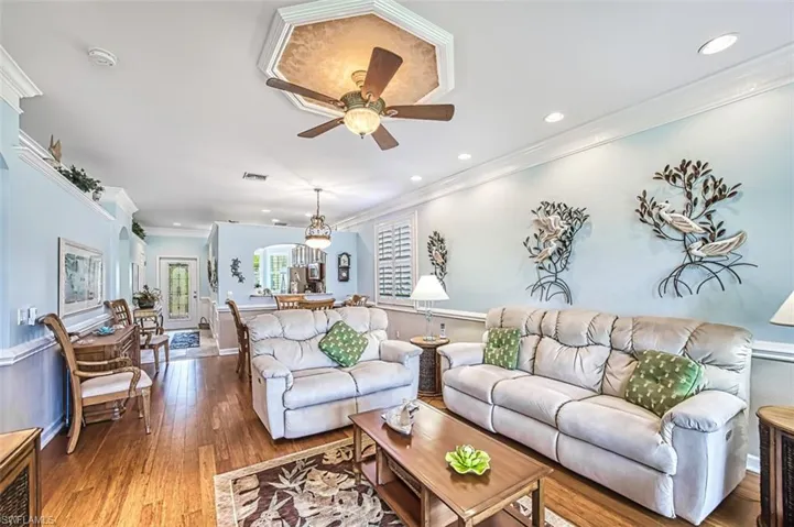 Living room with crown molding, hardwood / wood-style flooring, and ceiling fan