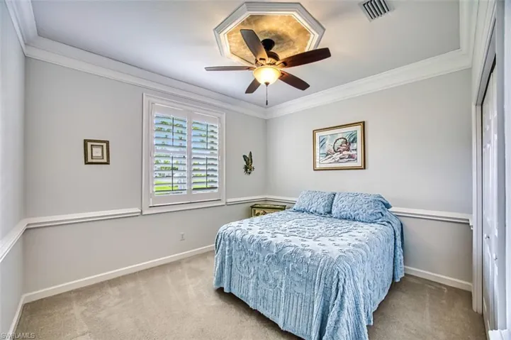 Bedroom with crown molding, carpet, and ceiling fan