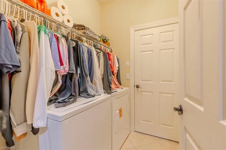 Laundry room with light tile patterned floors and independent washer and dryer