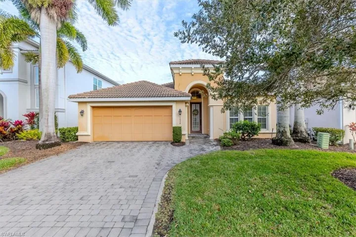 Mediterranean / spanish-style house with a front lawn, stucco siding, decorative driveway, a garage, and a tile roof