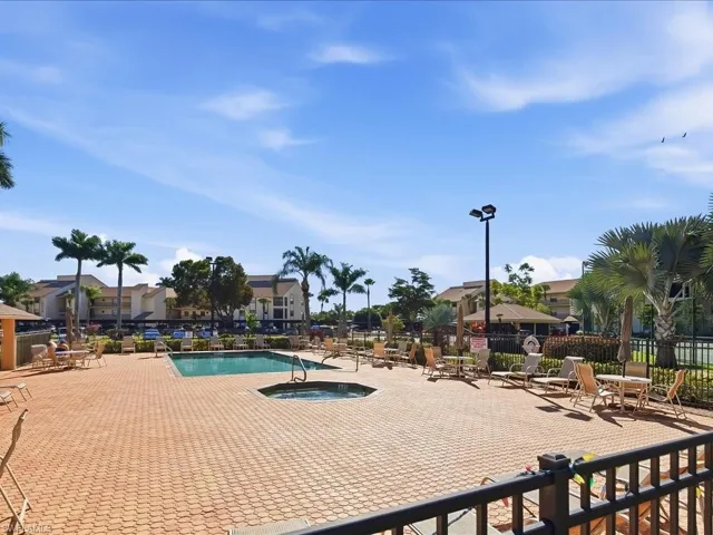 Pool area featuring a rectangular swimming pool, octagonal spa, and extensive paver decking