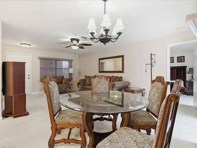 Recessed lighting, ceiling fan, and chandelier fixtures illuminate this living space