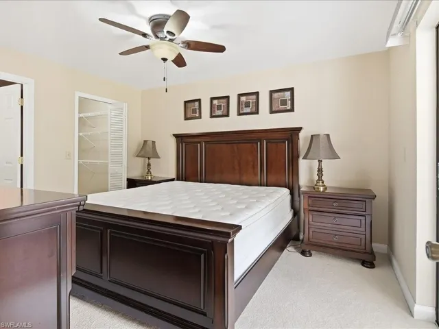 Overhead ceiling fan with light kit, built-in closet with bi-fold doors, and neutral wall color