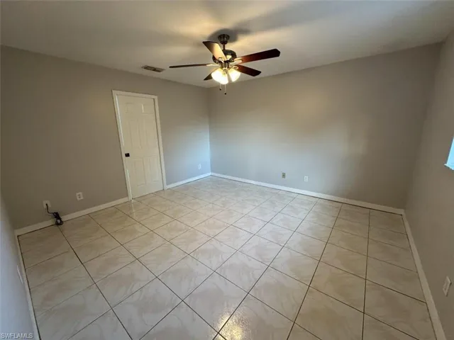 Spare room with light tile patterned floors and a ceiling fan