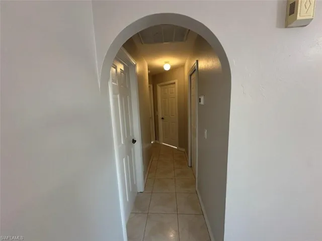 Hall with arched walkways and light tile patterned floors
