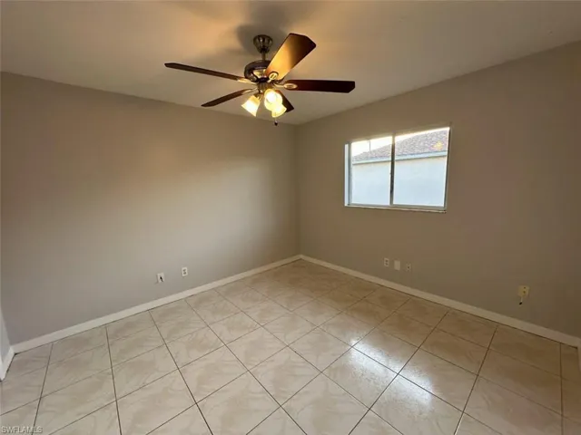 Unfurnished room featuring a ceiling fan and light tile patterned flooring