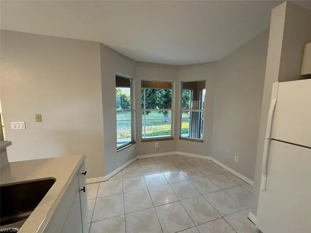 Unfurnished dining area featuring a sink and light tile patterned flooring
