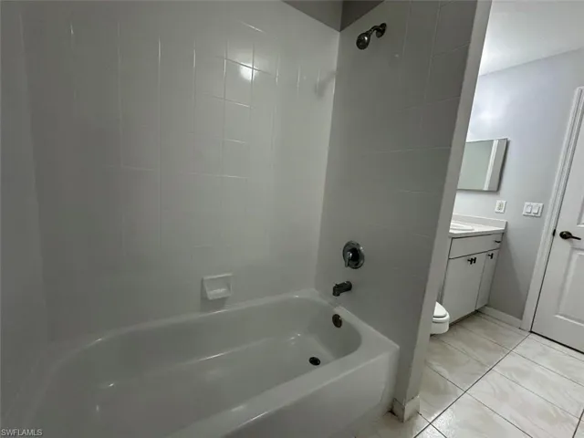 Bathroom featuring vanity, bathing tub / shower combination, and light tile patterned floors