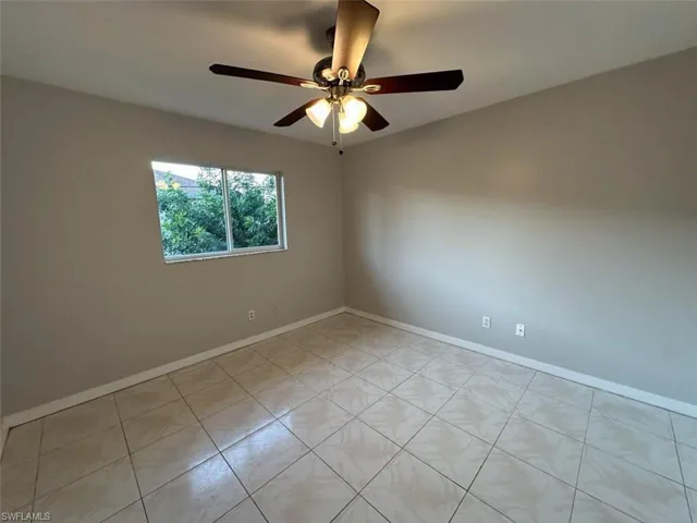 Spare room featuring light tile patterned flooring and ceiling fan