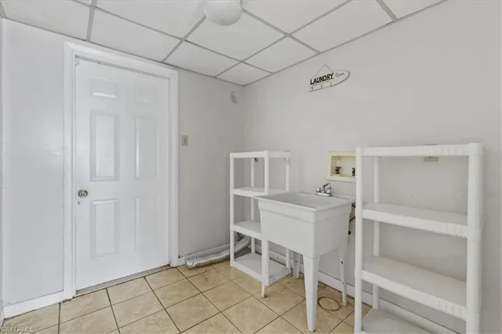 Washroom with hookup for a washing machine and light tile patterned floors