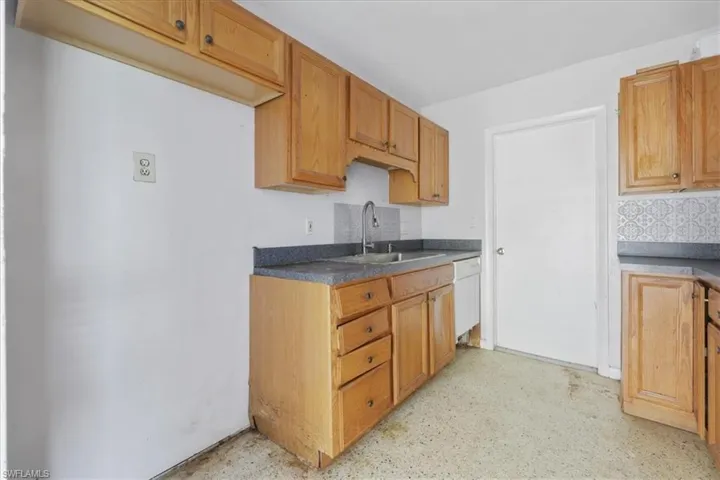 Kitchen featuring dishwasher and dark countertops