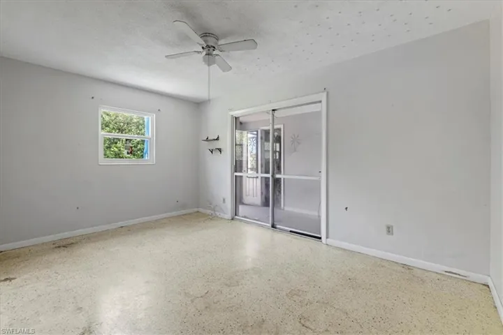 Unfurnished room with ceiling fan, speckle patterned floor, and a textured ceiling