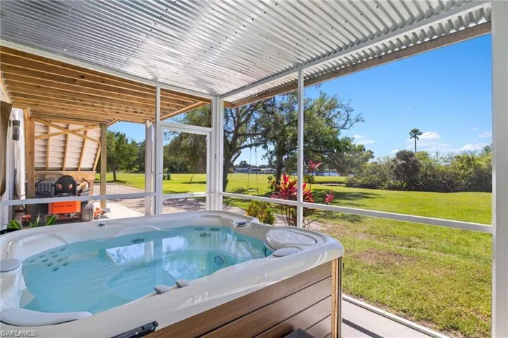 View of pool featuring a hot tub and a yard