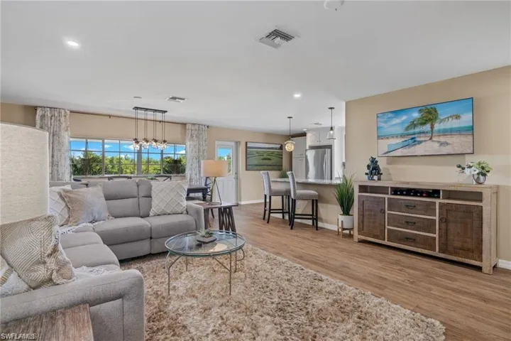 Living room with an inviting chandelier and light hardwood / wood-style floors
