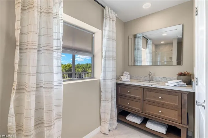 Bathroom with vanity, curtained shower, and tile patterned flooring