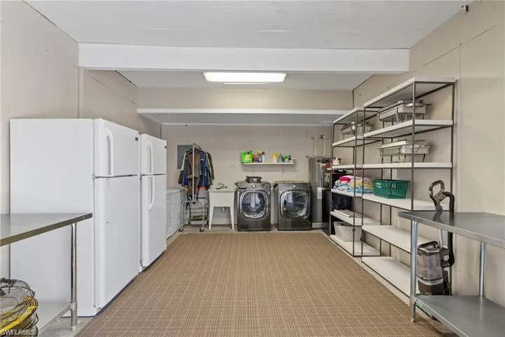 Washroom featuring sink, water heater, and separate washer and dryer