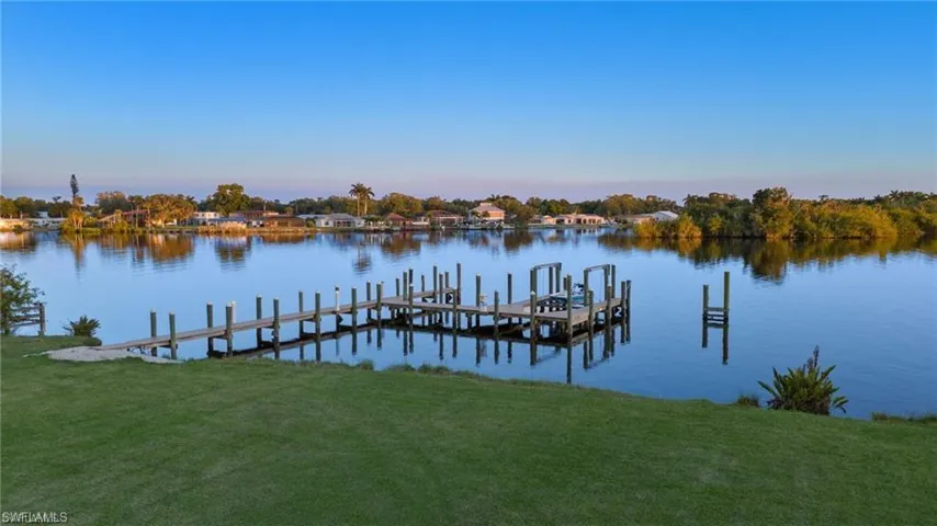 View of dock with a yard and a water view
