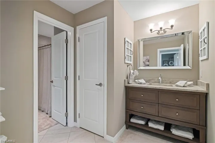 Bathroom with vanity, tile patterned floors, and a shower with shower curtain