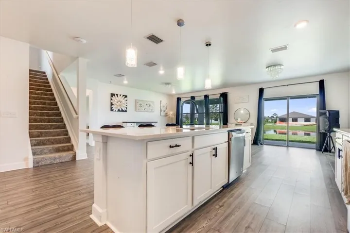 Kitchen with stainless steel dishwasher, sink, and a kitchen island