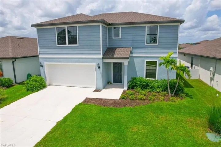 Front of property featuring a garage and a front lawn