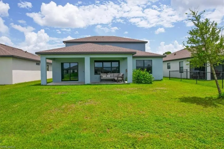 Rear view of property with a lawn, an outdoor living space, and a patio area