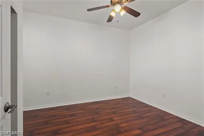 Unfurnished room with dark wood finished floors and ceiling fan