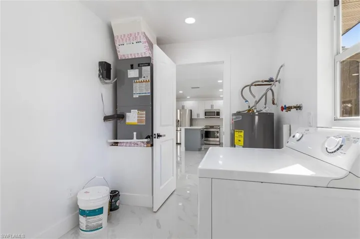 Laundry area featuring washer / dryer and electric water heater