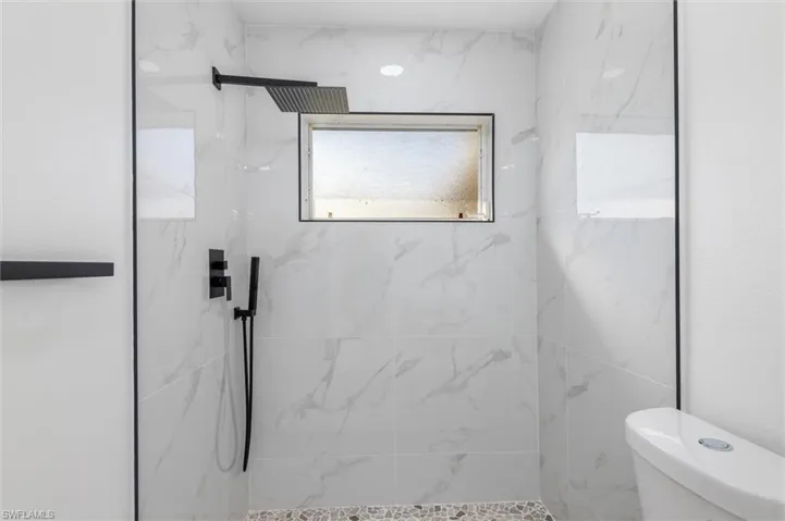 Bathroom featuring toilet and tiled shower