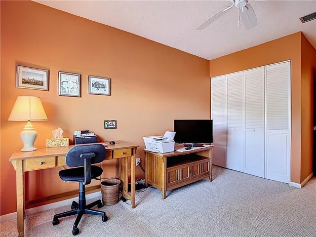 Home office with light carpet, a textured ceiling, and ceiling fan