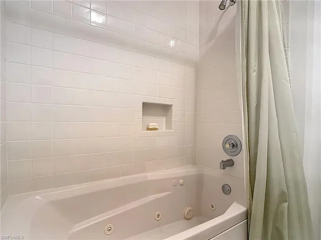 Full bath with a combined bath / shower with jetted tub