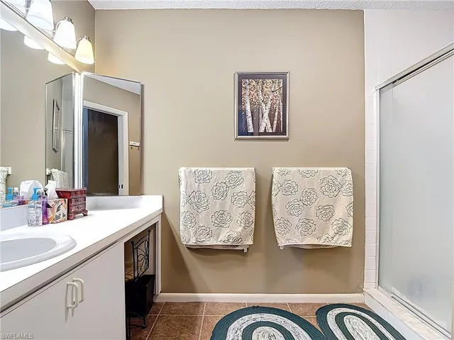 Bathroom featuring vanity, tile patterned floors, and a stall shower