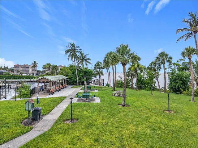 View of community with a yard, a water view, and a patio area