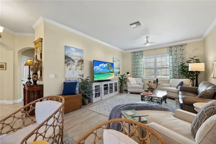 Light and bright. Freshly painted great room looking outward to lake and entry foyer.