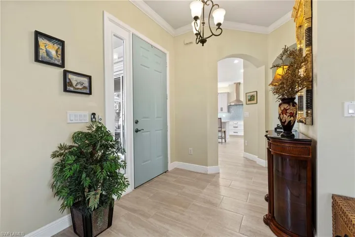Foyer entrance with an inviting chandelier and ornamental molding