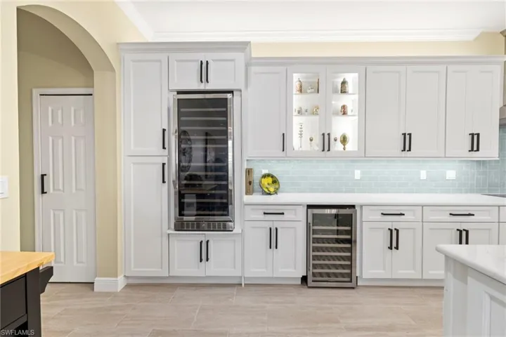 Close up of cabinetry, back splash, wine beverage coolers.