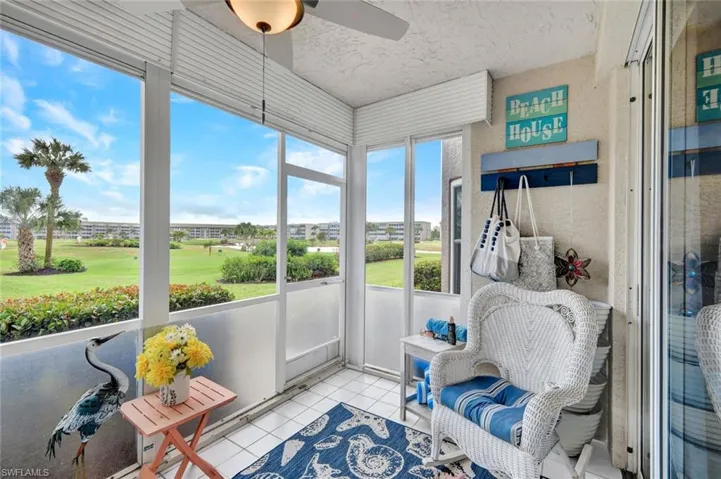 Sunroom with a ceiling fan and golf course view