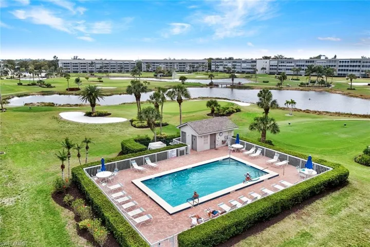 Community pool with a patio area, golf course view, a water view, and an outdoor structure