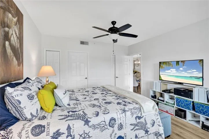 Bedroom with a ceiling fan, wood finished floors, and a walk-in closet
