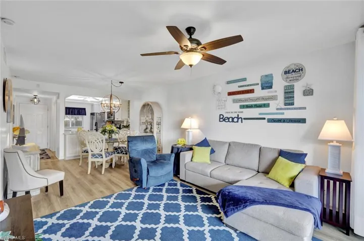 Living room with light wood-style floors, a ceiling fan