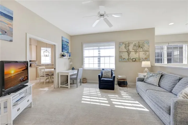 Living room with a ceiling fan and light carpet