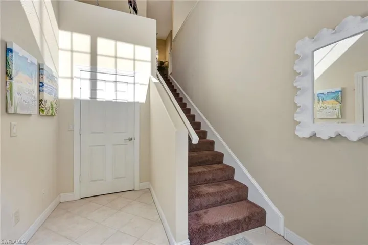 Entryway featuring light tile patterned flooring and stairs
