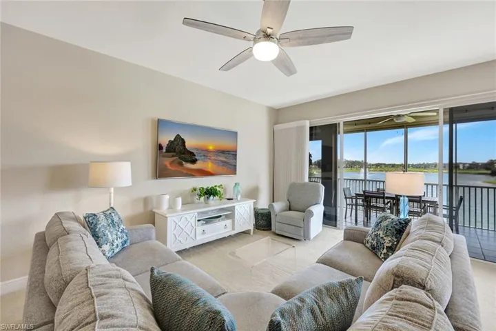 Living area with light carpet and ceiling fan