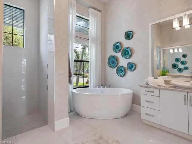 Bathroom featuring tile patterned flooring, vanity, and plus walk in shower
