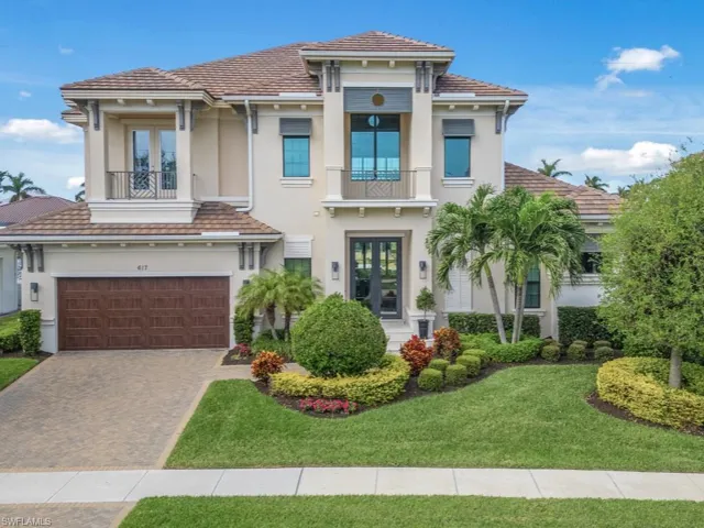 View of front of house with french doors, a balcony, a garage, and a front lawn