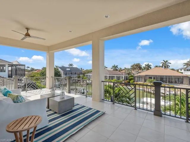 View of patio with ceiling fan, a balcony, and a water view